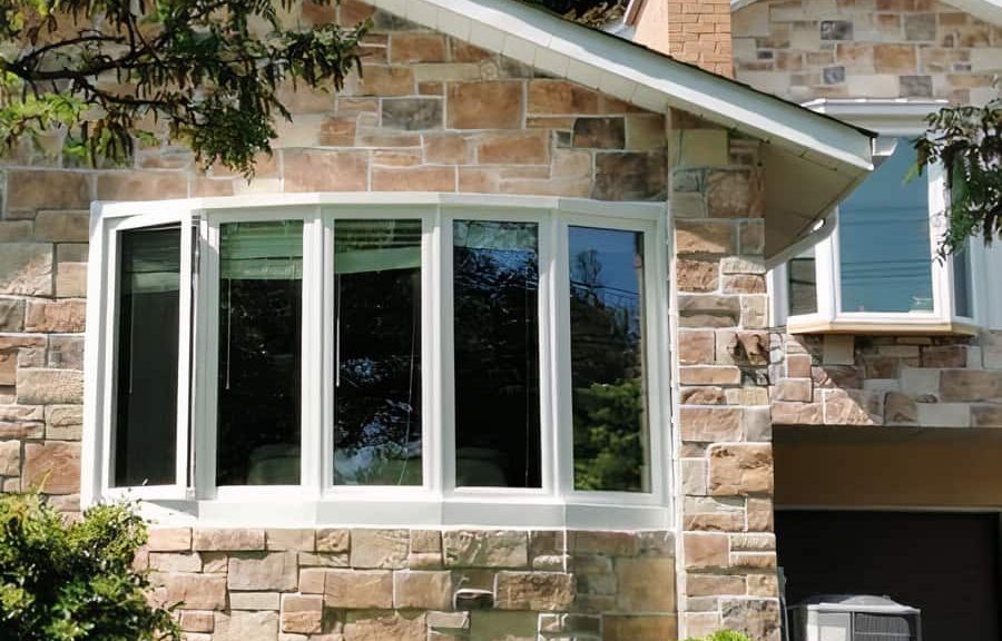 White framed bay window on stone wall