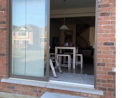 Glass sliding door opening into room.