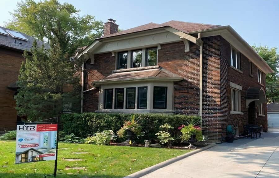 Two-story brick house with green yard.